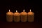 Four whiteÂ candlesÂ flameÂ burningÂ onÂ dark backgroundÂ withÂ copyÂ space forÂ text